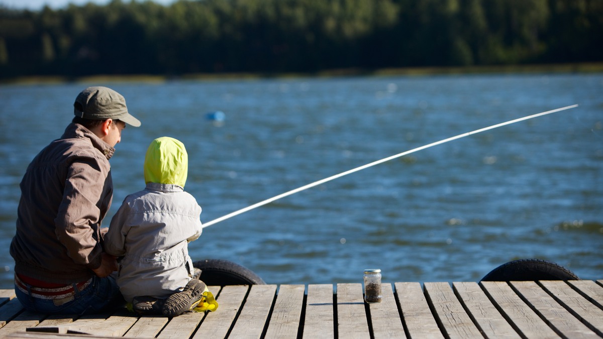 Bild: Pappa och barn sitter på bryggan och fiskar