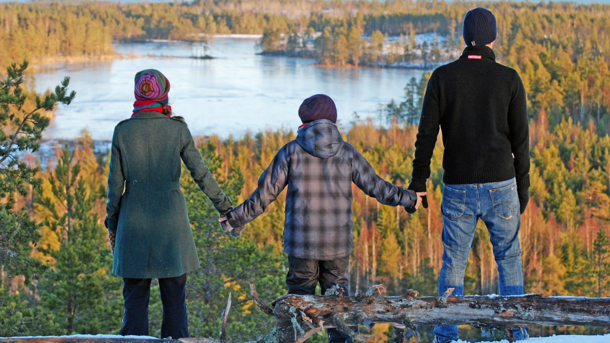 Bild: Familj på tre personer som håller hand medan de tittar på utsikten